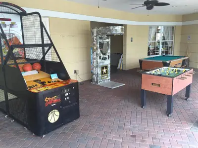 a room with a bunch of games and a table at VistaCay Balcony near Pool Convention Ctr iDrive in Orlando