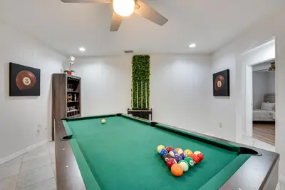 a pool table in a living room with afits at 7 Mi to Disney World Orlando Home with Private Pool in Orlando