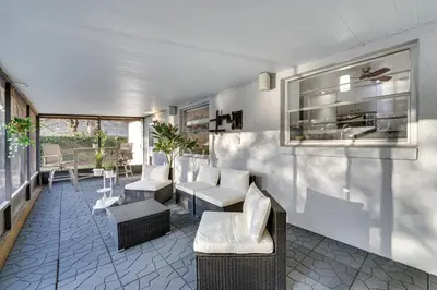 a living room with chairs and a couch and tables at 7 Mi to Disney World Orlando Home with Private Pool in Orlando