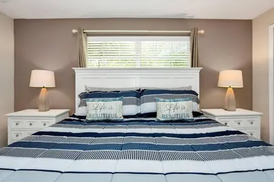 a bedroom with a bed with blue and white pillows at Lovely Family Home - 10min to Disney - STL107 in Kissimmee