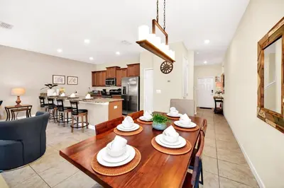 a kitchen and living room with a table and chairs at Lovely Family Home - 10min to Disney - STL107 in Kissimmee