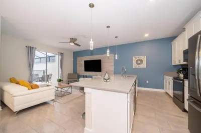 a kitchen and living room with a couch and a table at 5013MO TOWNHOUSE 4 BEDROOMS & 3 BATHROOMS + POOL in Kissimmee