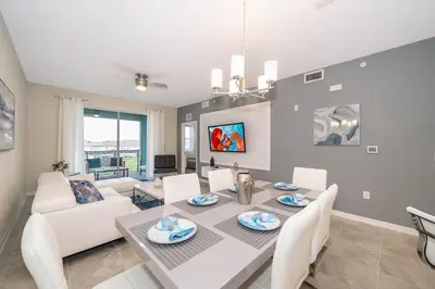 a dining room and living room with a table and chairs at 3121-304FR STOREY LAKE, CONDO 2/2 LAKE VIEW in Kissimmee