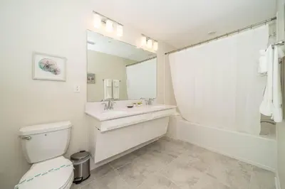 a bathroom with a sink and a toilet and a mirror at 3121-304FR STOREY LAKE, CONDO 2/2 LAKE VIEW in Kissimmee