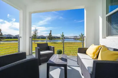 a porch with a couch and chairs and a table at 3131-102JJ STOREY LAKE, CONDO 2/2 LAKE VIEW in Kissimmee