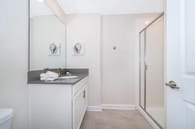a white bathroom with a sink and a mirror at 4301WB TOWNHOUSE 5 BEDROOMS & 4 BATHROOMS + POOL in Kissimmee