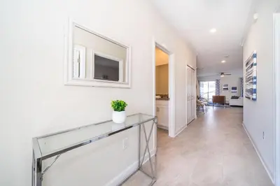 a hallway with a glass table and a tv on a wall at 4301WB TOWNHOUSE 5 BEDROOMS & 4 BATHROOMS + POOL in Kissimmee