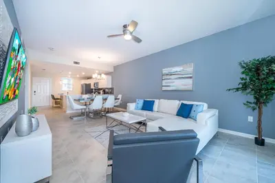 a living room with a white couch and a tv at 3141-204LS STOREY LAKE, CONDO 2/2 LAKE VIEW in Kissimmee