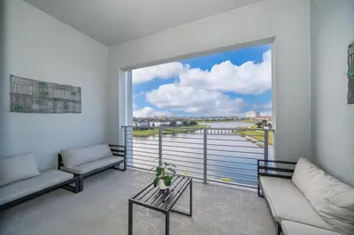 a living room with a large window with a view of the water at 3131-403AR STOREY LAKE, CONDO 2/2 LAKE VIEW in Kissimmee