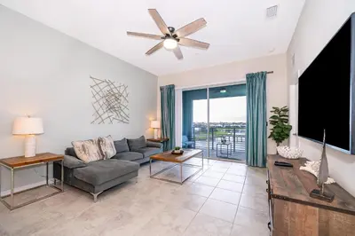 a living room with a couch and a flat screen tv at 3131-403AR STOREY LAKE, CONDO 2/2 LAKE VIEW in Kissimmee