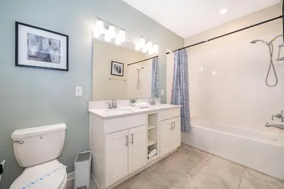a bathroom with a sink and a toilet and a tub at 3131-403AR STOREY LAKE, CONDO 2/2 LAKE VIEW in Kissimmee