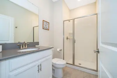 a bathroom with a toilet and a glass shower at 2921DH TOWNHOUSE 4 BEDROOMS & 3 BATHROOMS + POOL in Kissimmee