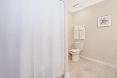 a bathroom with a toilet and a shower curtain at 3141-202RF STOREY LAKE, CONDO 2/2 LAKE VIEW in Kissimmee