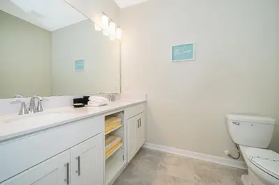 a bathroom with a sink and a toilet and a mirror at 3141-405IL STOREY LAKE, CONDO 2/2 LAKE VIEW in Kissimmee
