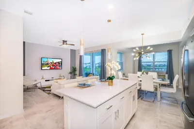 a kitchen and living room with a white counter top at 3131-202JQ STOREY LAKE, CONDO 2/2 LAKE VIEW in Kissimmee