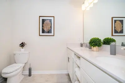 a white bathroom with a toilet and a sink at 3131-202JQ STOREY LAKE, CONDO 2/2 LAKE VIEW in Kissimmee