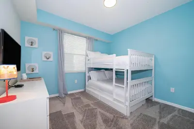 a bedroom with blue walls and a bunk bed at 3131-305RA STOREY LAKE, CONDO 2/2 LAKE VIEW in Kissimmee
