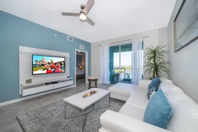 a living room with a white couch and a tv at 3131-305RA STOREY LAKE, CONDO 2/2 LAKE VIEW in Kissimmee
