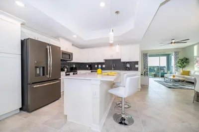 a kitchen with white cabinets and a stainless steel refrigerator at 3161-308AB STOREY LAKE, CONDO 3/2 LAKE VIEW in Kissimmee