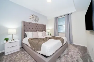 a white bedroom with a large bed and a window at 3151-207NC STOREY LAKE, CONDO 2/2 LAKE VIEW in Kissimmee