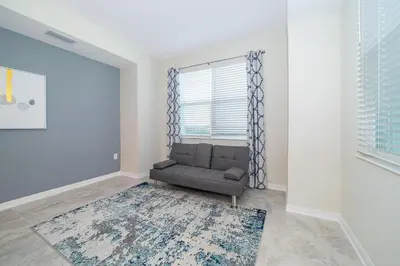 a living room with a couch and a window at 3151-307BE STOREY LAKE, CONDO 2/2 LAKE VIEW in Kissimmee