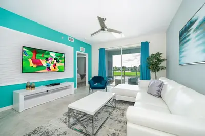 a living room with a white couch and a tv at 3161-205RF STOREY LAKE, CONDO 2/2 LAKE VIEW in Kissimmee