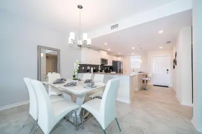 a dining room and kitchen with a white table and chairs at 3161-205RF STOREY LAKE, CONDO 2/2 LAKE VIEW in Kissimmee