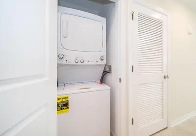 a small white washer and dryer in a room at 3161-203FC STOREY LAKE, CONDO 2/2 LAKE VIEW in Kissimmee