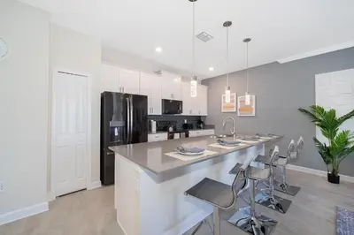 a kitchen with a large counter and a refrigerator at 4381FA TOWNHOUSE 4 BEDROOMS & 3 BATHROOMS + POOL in Kissimmee