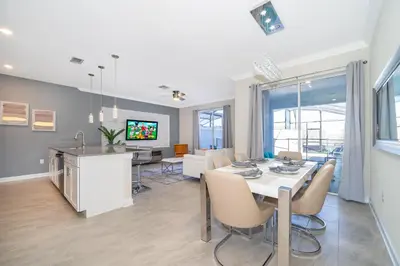 a dining room and kitchen with a table and chairs at 4381FA TOWNHOUSE 4 BEDROOMS & 3 BATHROOMS + POOL in Kissimmee