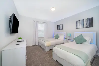 a bedroom with two beds and a television in it at 2984JP TOWNHOUSE 4 BEDROOMS & 3 BATHROOMS + POOL in Kissimmee