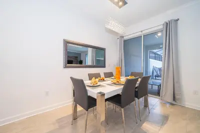 a dining room with a table and chairs at 2984JP TOWNHOUSE 4 BEDROOMS & 3 BATHROOMS + POOL in Kissimmee