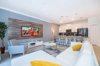 a living room with a white couch and a table at 2984JP TOWNHOUSE 4 BEDROOMS & 3 BATHROOMS + POOL in Kissimmee