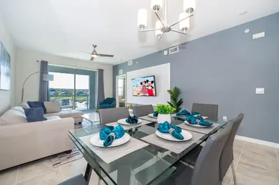 a dining room with a glass table and a couch at 3171-204AZ STOREY LAKE, CONDO 2/2 LAKE VIEW in Kissimmee