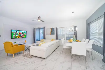 a living room with a white couch and a tv at 3005PB TOWNHOUSE 5 BEDROOMS & 4 BATHROOMS + POOL in Kissimmee