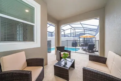 a living room with wicker chairs and a table at 4202MC TOWNHOUSE 4 BEDROOMS & 3 BATHROOMS + POOL in Kissimmee
