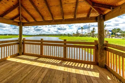 a wooden porch with a view of a lake at Last Minute Disney Getaway Townhouse with Private Pool. Book Now 17066 in Kissimmee
