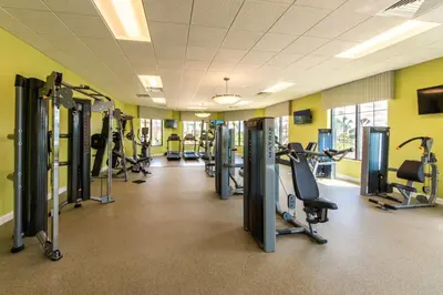 a gym with rows of treadmills and cardio machines at Last Minute Disney Getaway! Private Pool, Hot Tub & Games Room. Book Now! #17074 in Kissimmee