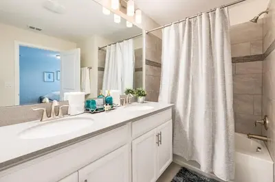 a white bathroom with a sink and a shower at Last Minute Disney Getaway Townhouse with Private Pool. Book Now 21174 in Kissimmee