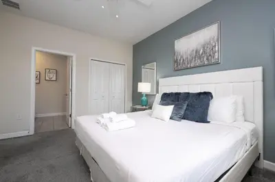 a bedroom with a large white bed in a room at Last Minute Disney Private Pool Hot Tub Game Room Themed Bedrooms. Book Now 29466 in Kissimmee