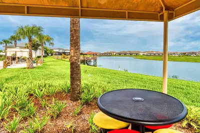 a table and chairs with a view of a lake at Last Minute Disney Getaway! Private Pool, Hot Tub & Games Room. Book Now! #17050 in Kissimmee