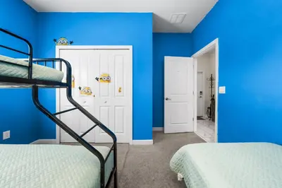 a bedroom with blue walls and two bunk beds at Roomy Family Home-Sleeps 16 STL110 in Kissimmee