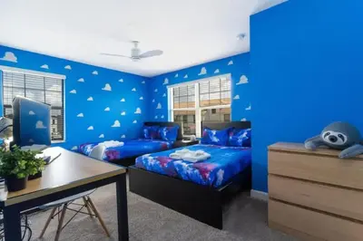 a blue bedroom with two beds and a desk at Roomy Family Home-Sleeps 16 STL110 in Kissimmee