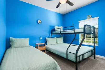 two bunk beds in a room with blue walls at Roomy Family Home-Sleeps 16 STL110 in Kissimmee