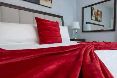 a red pillow on a bed with a red blanket at Epic Location 3BR Home w Full Comfort in Orlando