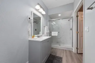 a white bathroom with a sink and a shower at Epic Location 3BR Home w Full Comfort in Orlando