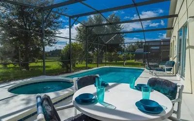 a table and chairs next to a swimming pool at 2025 Vacation Savings Secure Your Spot Today in Orlando