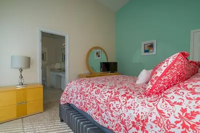 a bedroom with a red and white bed and a mirror at 2025 Vacation Savings Secure Your Spot Today in Orlando