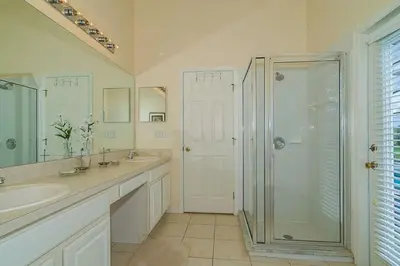 a white bathroom with a shower and a sink at 2025 Vacation Savings Secure Your Spot Today in Orlando