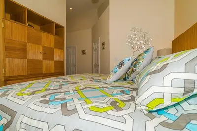a bedroom with a bed with a colorful comforter and pillows at 2025 Vacation Savings Secure Your Spot Today in Orlando